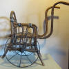 rare doll's chair/cart in bentwood, with caned seat. Iron wheels. Early 1900