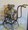 rare doll's chair/cart in bentwood, with caned seat. Iron wheels. 
